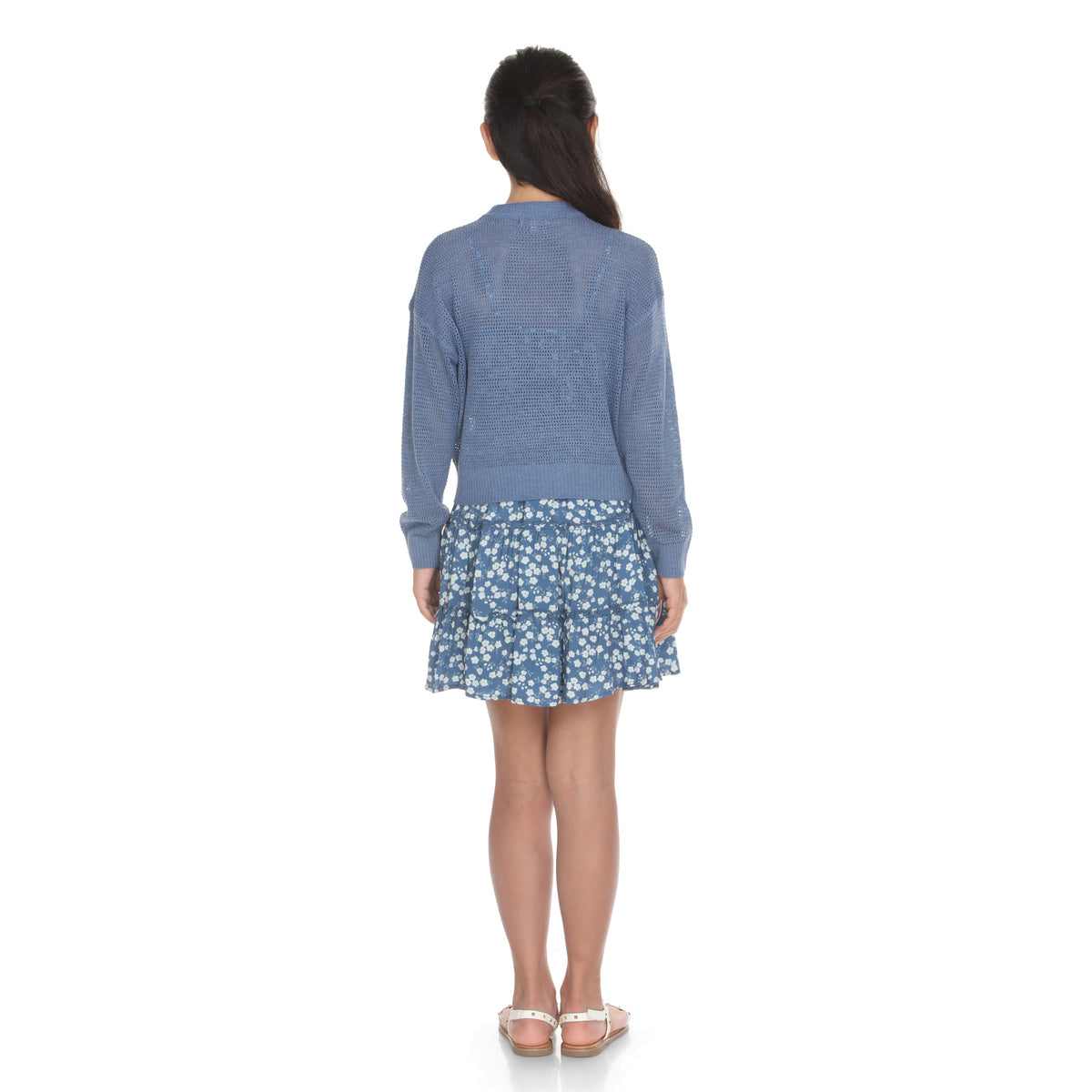 Back view of the blue sweater and floral dress set on model, showing dropped shoulders and tiered skirt